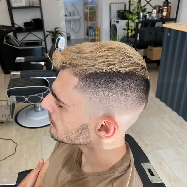 Blond vlasy učesané dohora so skin fadom po stranách