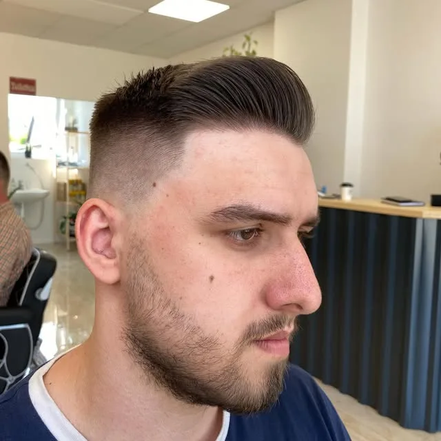 Tmavý quiff s vysokým fadom a upravenou bradou